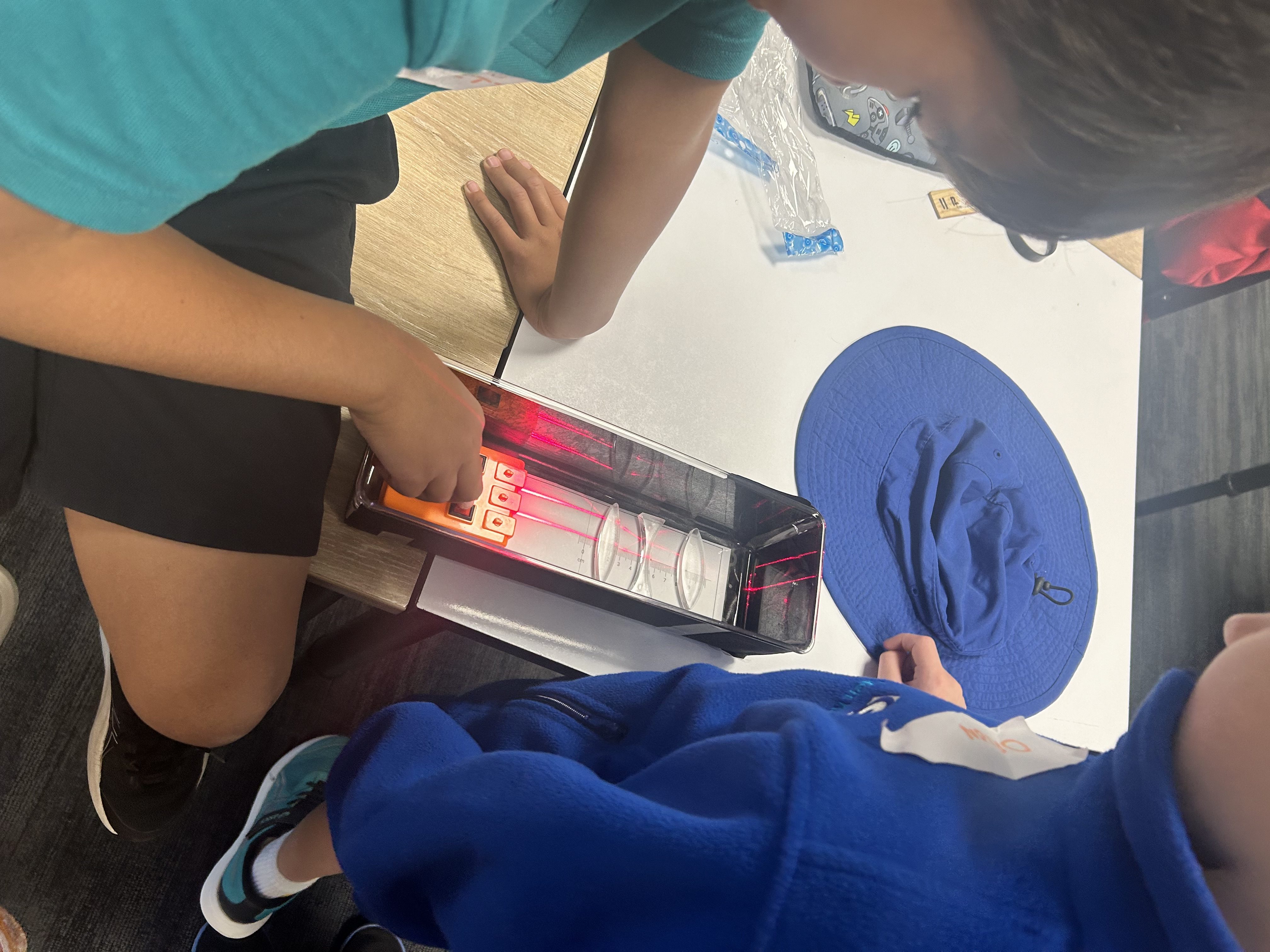 Child peering into a UV and blue light imaging box during an Imaging Lab STEM workshop