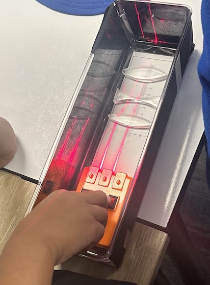 Laser light bending through lenses and prisms during a Light Lab STEM workshop